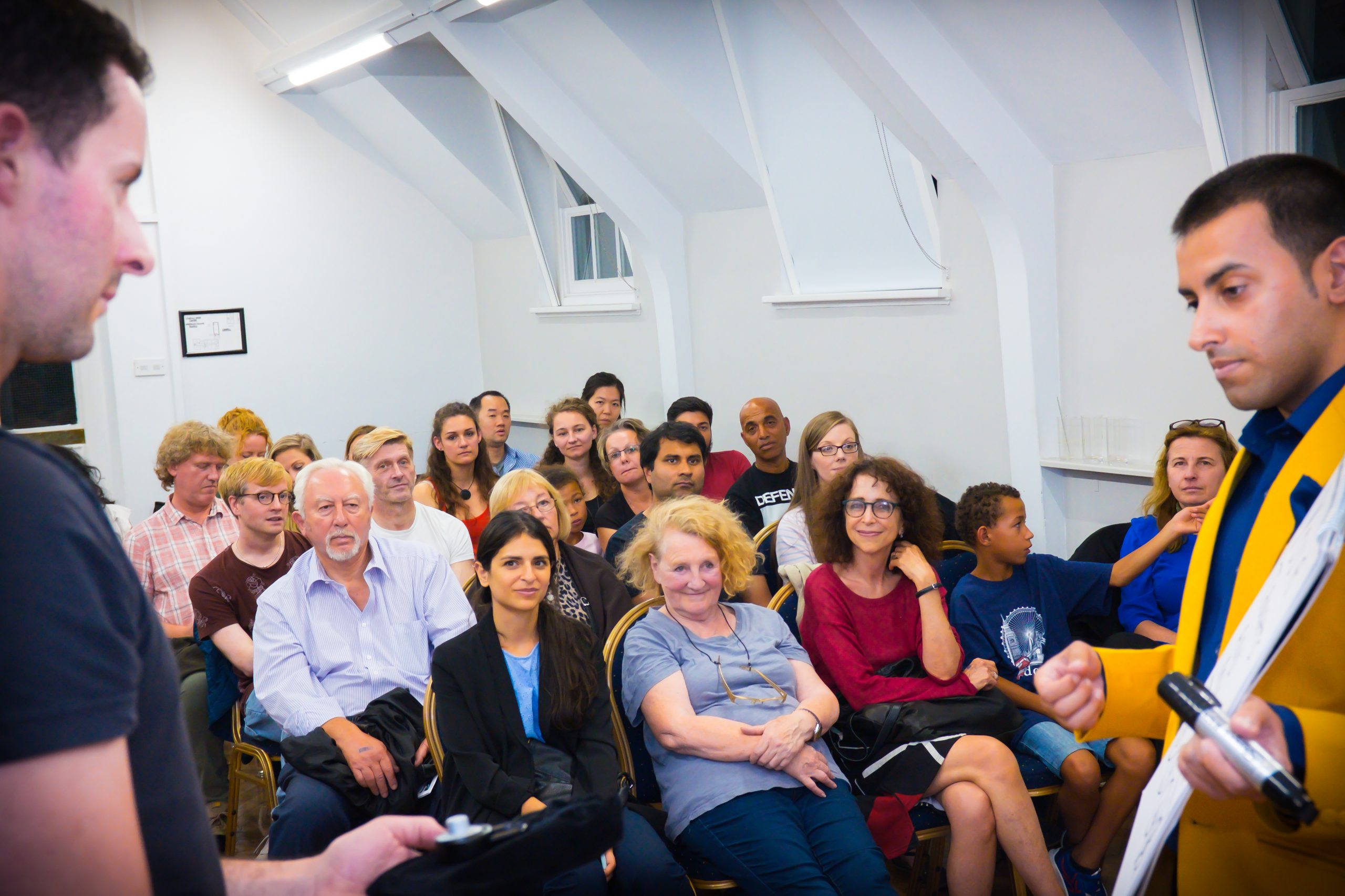 Is this stylish man in a Bananaman suit giving a presentation or entertaining an audience on stage?