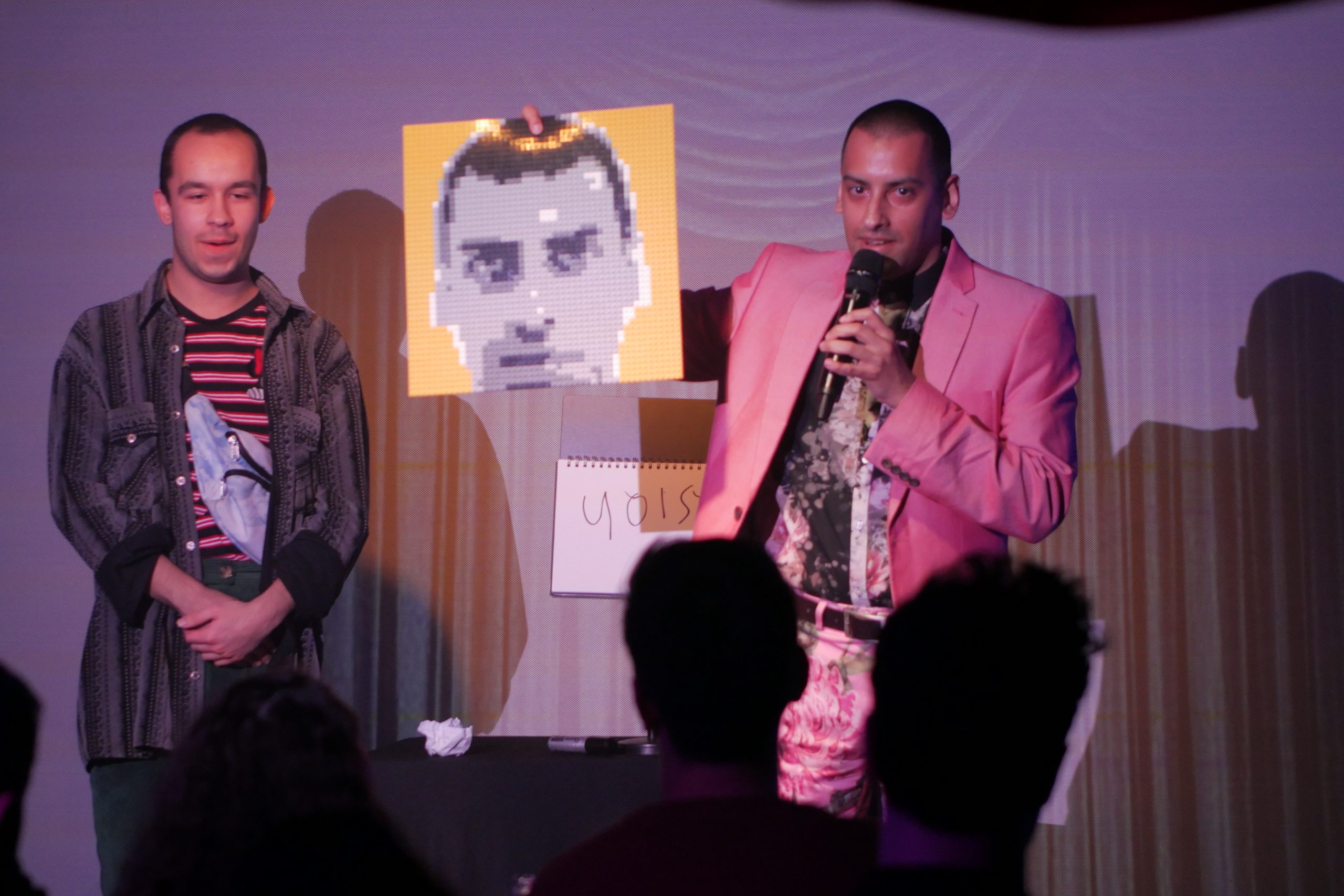 Dressed in a pretty in pink suit, holding a bespoke piece of art - made from lego pieces, at a cabaret show in London's West End
